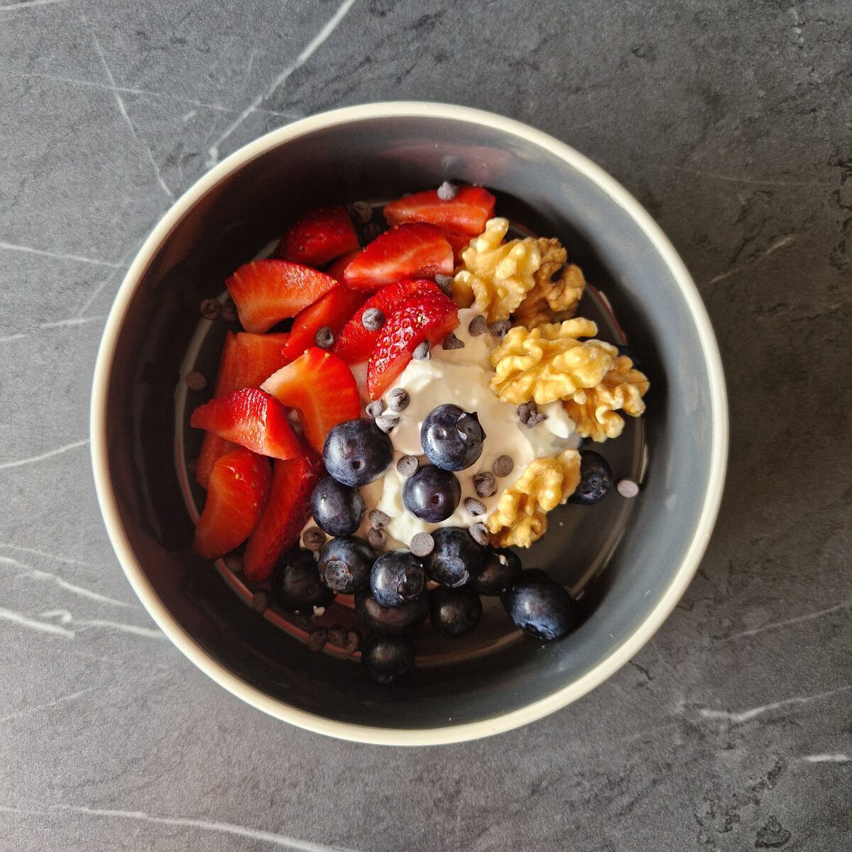 Yogurt con frutti di bosco, noci e gocce di cioccolato